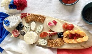 fromages de cocagne un plateau de fromages avec des fruits et le drapeau français en fond